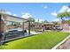 Beautiful backyard featuring lush lawn, covered patio, tiki bar, and outdoor seating, perfect for entertaining at 10645 Redwood Grove Ave, Las Vegas, NV 89144