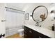 Stylish bathroom with a modern vanity, round mirror, and patterned shower curtain at 10645 Redwood Grove Ave, Las Vegas, NV 89144