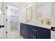 Bathroom featuring a modern vanity with gold hardware and a shower with marble-like tiling at 10645 Redwood Grove Ave, Las Vegas, NV 89144