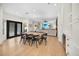Bright dining room with light wood floors, table with black chairs, and view of the living room at 10645 Redwood Grove Ave, Las Vegas, NV 89144