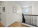 Bright hallway featuring hardwood floors, fresh paint, updated fixtures, and staircase with black wooden balusters at 10645 Redwood Grove Ave, Las Vegas, NV 89144