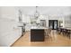 Modern kitchen with white cabinets, stainless steel appliances, island with seating, and dining area at 10645 Redwood Grove Ave, Las Vegas, NV 89144