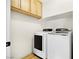 Functional laundry room with modern washer and dryer, and overhead storage cabinets at 10645 Redwood Grove Ave, Las Vegas, NV 89144