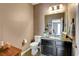 Elegant half bathroom featuring modern fixtures, dark cabinetry, and a decorative mirror at 10656 Hyde Corner Ave, Las Vegas, NV 89166