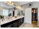 Bathroom featuring double sinks, dark cabinetry, tiled floor, stylish decor and walk-in closet at 10656 Hyde Corner Ave, Las Vegas, NV 89166