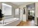 Bathroom featuring a soaking tub, glass shower and private entry to the bedroom at 10656 Hyde Corner Ave, Las Vegas, NV 89166