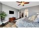 Spacious bedroom with ceiling fan, stylish wood flooring, and mounted TV at 10656 Hyde Corner Ave, Las Vegas, NV 89166