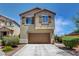 Two-story home featuring a well-manicured front yard and a brown two-car garage at 10656 Hyde Corner Ave, Las Vegas, NV 89166