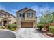 Two-story home with an attached two car garage, manicured landscaping, and sidewalk at 10656 Hyde Corner Ave, Las Vegas, NV 89166