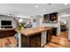 Open concept kitchen with a large island and dark cabinets overlooking living area at 10656 Hyde Corner Ave, Las Vegas, NV 89166