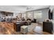 Inviting living room featuring a leather sofa, hardwood floors, and an open layout to the kitchen at 10656 Hyde Corner Ave, Las Vegas, NV 89166