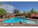 Beautiful backyard pool featuring a central rock waterfall and surrounding brick patio at 10656 Hyde Corner Ave, Las Vegas, NV 89166
