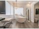 Modern bathroom highlighting a stylish soaking tub, chandelier, and sophisticated design at 11 Knob Oak Dr, Henderson, NV 89052