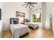 Bright bedroom featuring two twin beds, wood floors, ceiling fan and a large window overlooking the exterior at 11 Knob Oak Dr, Henderson, NV 89052