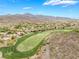 Aerial view of a lush green golf course surrounded by desert landscape and mountain views at 11 Knob Oak Dr, Henderson, NV 89052