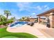 Sparkling backyard pool and spa with seating area, palm trees, and lush landscaping at 11 Knob Oak Dr, Henderson, NV 89052