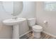 Bright half bathroom featuring a pedestal sink, a round mirror, and wood-look flooring at 1102 E Dorrell Ln, North Las Vegas, NV 89086