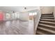 Spacious living room with wood-look floors, recessed lighting, and stairs leading to the second floor at 1102 E Dorrell Ln, North Las Vegas, NV 89086