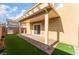 Covered patio featuring brick flooring and artificial grass in the backyard at 1102 E Dorrell Ln, North Las Vegas, NV 89086