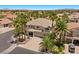 Aerial view showcasing a stunning two-story home featuring a spacious driveway, and a lush landscaped yard with palm trees at 11056 Kilkerran Ct, Las Vegas, NV 89141