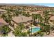 An aerial view of a luxury home with a pool, spa and a backyard surrounded by lush landscaping and palm trees at 11056 Kilkerran Ct, Las Vegas, NV 89141