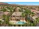 Expansive aerial view of a home with a private pool surrounded by lush landscaping and palm trees at 11056 Kilkerran Ct, Las Vegas, NV 89141