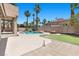 Inviting backyard with a sparkling pool, spa, fire pit, and mature palm trees for outdoor enjoyment at 11056 Kilkerran Ct, Las Vegas, NV 89141
