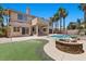 Backyard featuring a pool, fire pit, and lush landscaping at 11056 Kilkerran Ct, Las Vegas, NV 89141