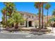 Elegant two-story home with covered entry, three-car garage, surrounded by palm trees and a landscaped yard at 11056 Kilkerran Ct, Las Vegas, NV 89141