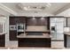 Close up of gourmet kitchen with stainless steel appliances, granite countertops, and dark wood cabinets at 11056 Kilkerran Ct, Las Vegas, NV 89141