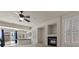 Spacious living room with a ceiling fan, fireplace, and a sliding door leading to the backyard at 11056 Kilkerran Ct, Las Vegas, NV 89141
