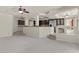 Open-concept living room featuring a ceiling fan and tiled steps leading to the kitchen and other living areas at 11056 Kilkerran Ct, Las Vegas, NV 89141