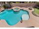 Sparkling pool featuring a spa, rock features, and a tanning shelf at 11056 Kilkerran Ct, Las Vegas, NV 89141