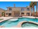 Backyard oasis featuring a large pool, spa, tanning shelf, and lush landscaping for relaxation and entertainment at 11056 Kilkerran Ct, Las Vegas, NV 89141