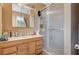 Bathroom featuring a vanity with wooden cabinets and a glass shower with natural light at 111 Narcissus Ln, Las Vegas, NV 89107