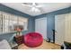 Bedroom with wood-look floors, blue walls, ceiling fan, and a large beanbag chair at 111 Narcissus Ln, Las Vegas, NV 89107