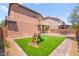 Private backyard featuring artificial grass, brick pavers, and outdoor seating area at 11274 Civita St, Las Vegas, NV 89141