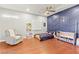 Charming bedroom with hardwood floors, ceiling fan, and modern blue accent wall at 11274 Civita St, Las Vegas, NV 89141