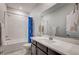 Well-lit bathroom features a large mirror, a modern vanity, and a shower-tub combination at 11402 Ethereal Landing Ave, Las Vegas, NV 89138