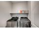 Convenient laundry room with modern washer and dryer units plus a shelf for storage at 11402 Ethereal Landing Ave, Las Vegas, NV 89138