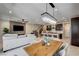 Open concept living room, dining area, and kitchen with modern light fixtures and stainless steel appliances at 11402 Ethereal Landing Ave, Las Vegas, NV 89138