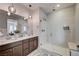 Modern bathroom features double sinks, decorative light fixtures, and a spacious walk-in shower at 11402 Ethereal Landing Ave, Las Vegas, NV 89138