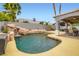 A serene backyard pool with a custom rock waterfall, set alongside a covered patio with outdoor seating at 1325 Baychester Dr, Henderson, NV 89002