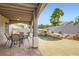 An outdoor patio featuring a tranquil pool with a rock waterfall, complemented by a shaded dining area at 1325 Baychester Dr, Henderson, NV 89002