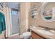 Cozy bathroom showcasing a vanity with a decorative mirror and a shower with glass doors at 1325 Baychester Dr, Henderson, NV 89002