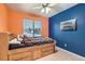 Colorful bedroom with blue and orange walls, a ceiling fan, and a window at 1325 Baychester Dr, Henderson, NV 89002