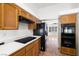 Well-lit kitchen featuring wood cabinets, black appliances, solid surface countertops and tile flooring at 170 Dove St, Pahrump, NV 89060