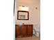 Bathroom featuring wood cabinets, a mirror, and a toilet at 1830 N Buffalo Dr # 1010, Las Vegas, NV 89128
