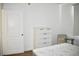 Cozy bedroom featuring a white dresser, bedside chair, and a door at 1830 N Buffalo Dr # 1010, Las Vegas, NV 89128