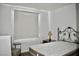 Bright bedroom with modern window shade, simple furnishings, and white walls at 1830 N Buffalo Dr # 1010, Las Vegas, NV 89128